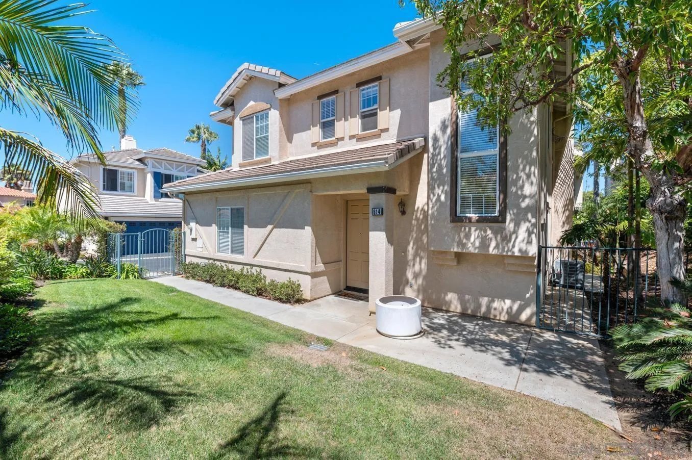614 Compass Court Carlsbad, CA 92011 - Photo 6 of 33 a view of a white house with a yard and table and chairs under an umbrella