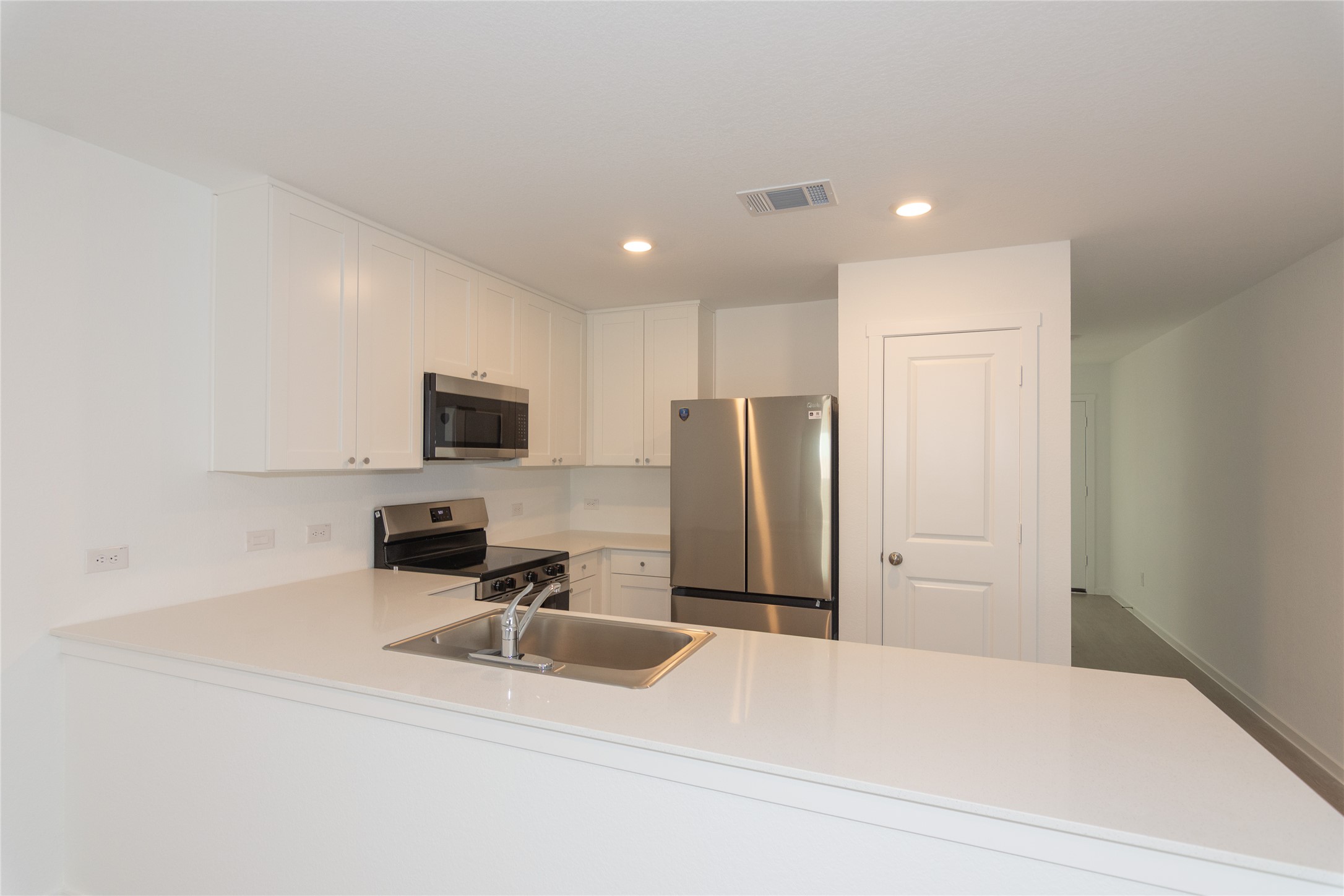 149 Star Packer Lane Jarrell, TX 76537 - Photo 11 of 30 A well-equipped kitchen features bright white cabinetry and sleek stainless steel appliances.