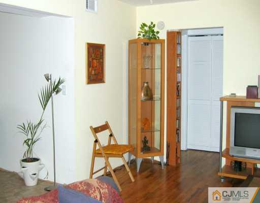 199 Evergreen Road, Unit 3A Edison, NJ 08837 - Photo 3 of 6 a living room with furniture and a flat screen tv