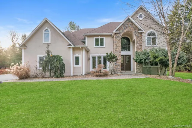 a front view of a house with yard and green space