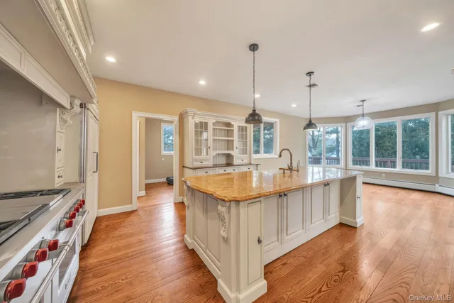 a large kitchen with stainless steel appliances granite countertop a large stove a sink and a wooden floors
