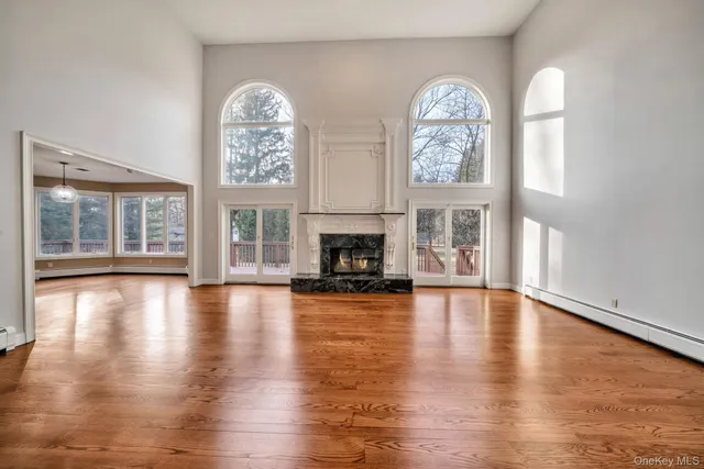 a view of empty room with wooden floor and fireplace
