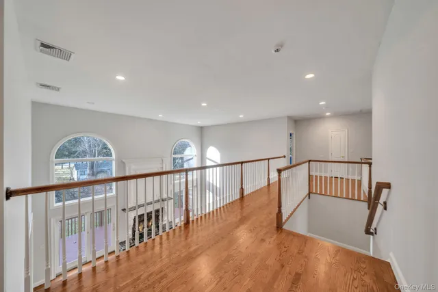 a view of staircase with lots of frames on wall and wooden floor