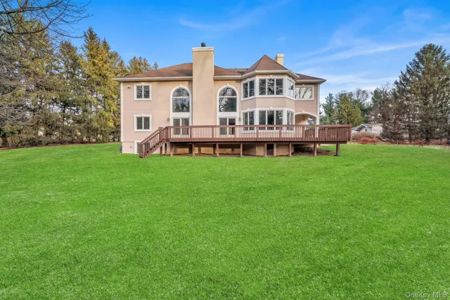 a view of a house with a big yard and large trees