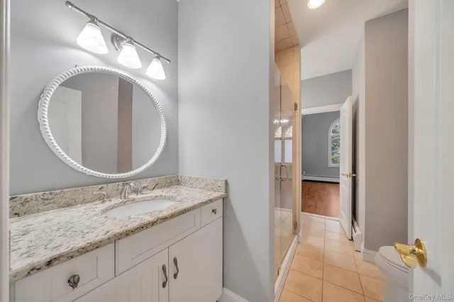 a bathroom with a granite countertop sink and a mirror