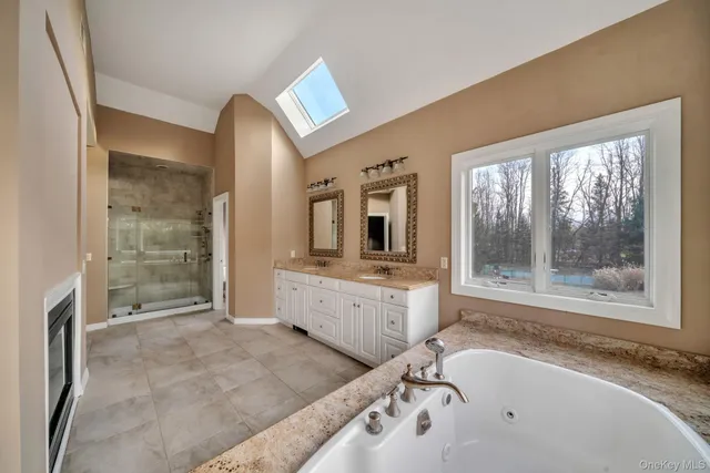 a bathroom with a granite countertop tub sink and mirror