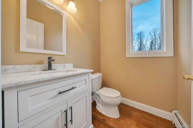 a bathroom with a granite countertop toilet sink and mirror
