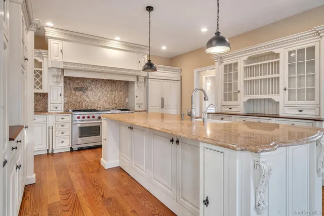 a kitchen with stainless steel appliances granite countertop a lot of counter space and wooden floors