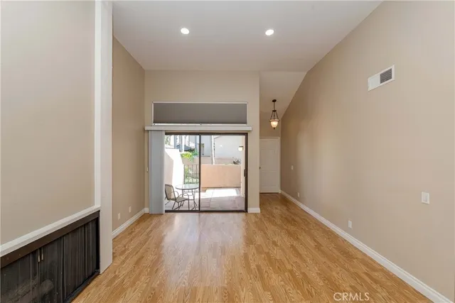 an empty room with wooden floor and a table