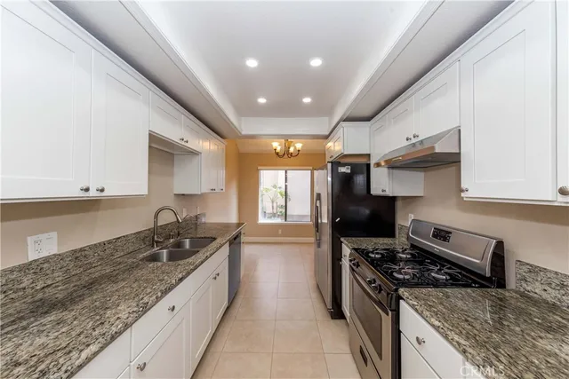 a kitchen with granite countertop a sink stainless steel appliances and cabinets