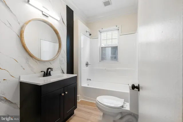 a bathroom with a toilet a sink and mirror