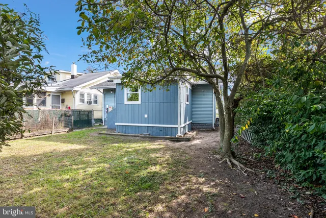 a view of a house with a yard and large tree