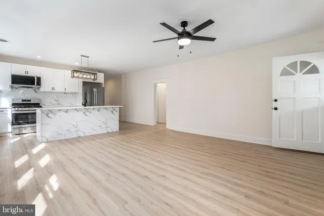a view of a kitchen with a sink and dishwasher with wooden floor