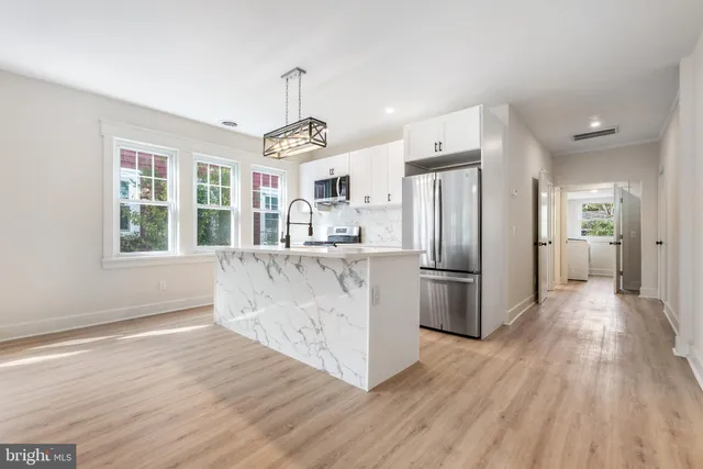 a kitchen with stainless steel appliances granite countertop a refrigerator and a stove top oven