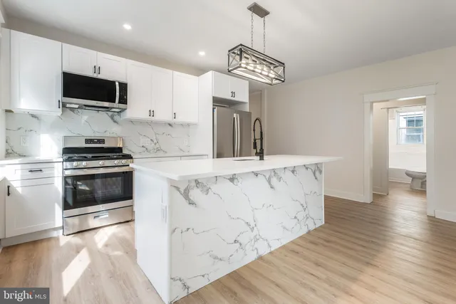 a kitchen with granite countertop a stove and a wooden floors