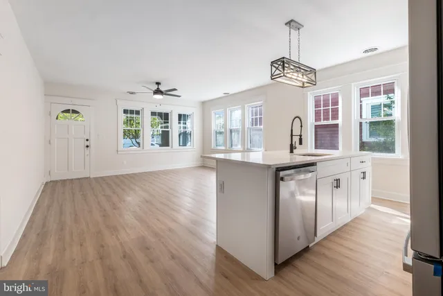 a kitchen with stainless steel appliances granite countertop wooden floors and white walls
