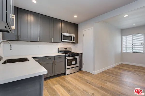 a kitchen with granite countertop stainless steel appliances and wooden cabinets