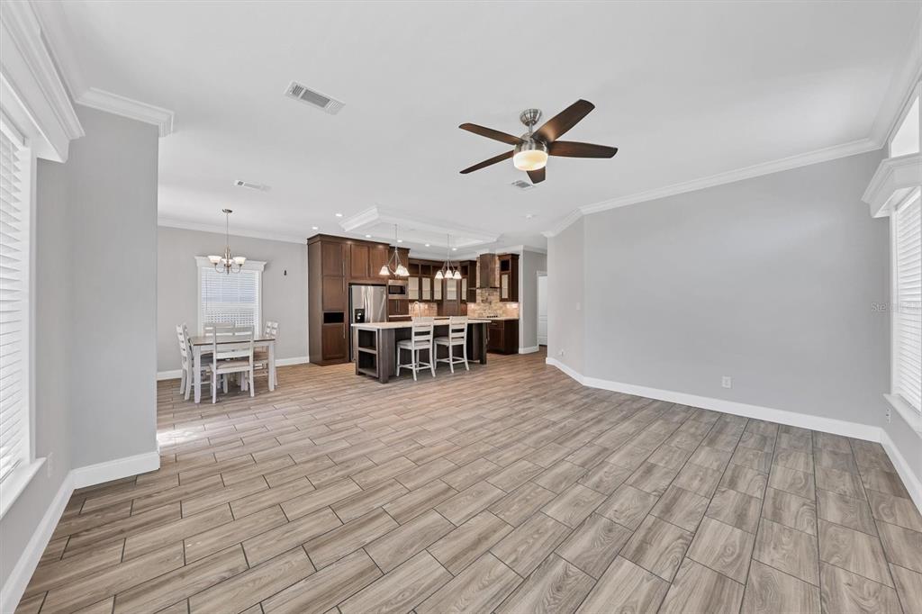 3607 70th Avenue East Ellenton, FL 34222 - Photo 8 of 43 a view of a room with wooden floor a ceiling fan and windows