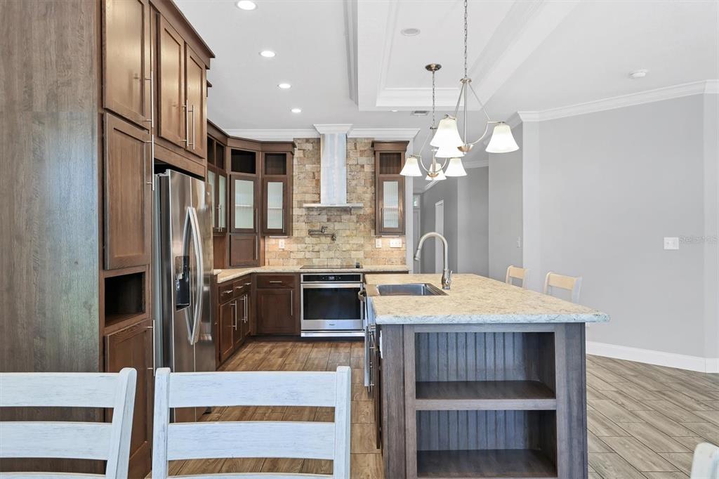 3607 70th Avenue East Ellenton, FL 34222 - Photo 10 of 43 a kitchen with kitchen island granite countertop a stove refrigerator and cabinets