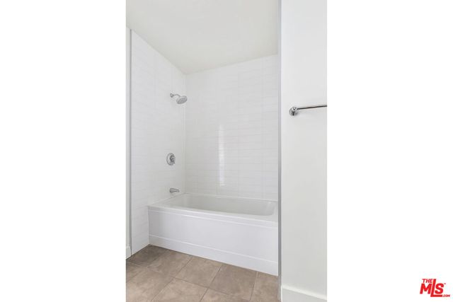 a bathroom with a tub shower and sink