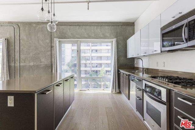 a kitchen with granite countertop a stove a sink and a refrigerator