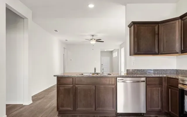 a kitchen with stainless steel appliances granite countertop a sink and cabinets