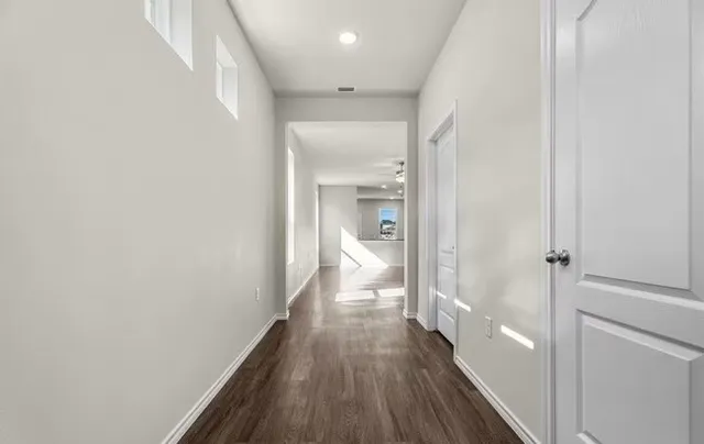 a view of a hallway with wooden floor