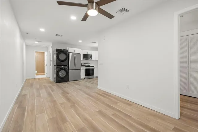 a kitchen with granite countertop a refrigerator oven a sink dishwasher and a stove with wooden floor