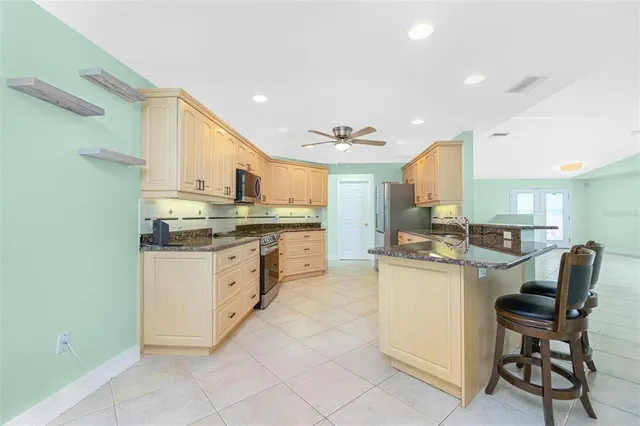 a kitchen with stainless steel appliances granite countertop a refrigerator and a stove top oven