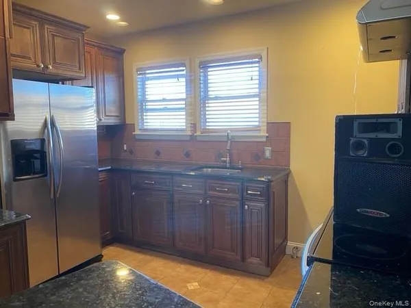 a kitchen with granite countertop a refrigerator and cabinets
