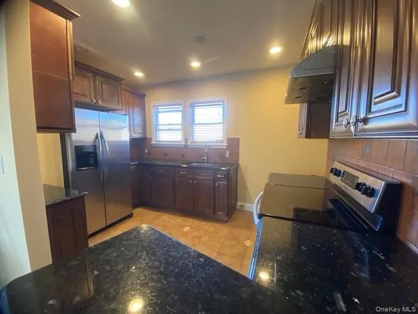 a kitchen with stainless steel appliances a refrigerator a sink a stove and island