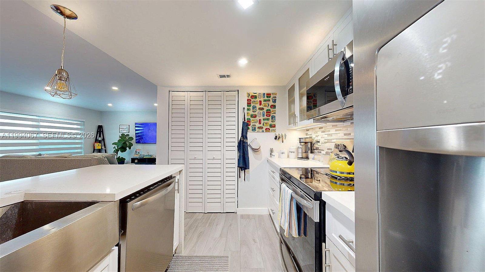6840 Southwest 45th Lane, Unit 5 Miami, FL 33155 - Photo 13 of 34 a kitchen with stainless steel appliances a refrigerator a stove a microwave and a refrigerator