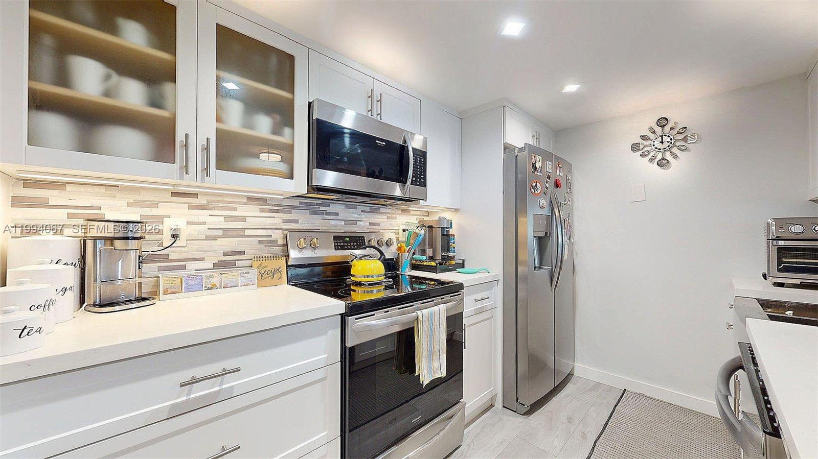 6840 Southwest 45th Lane, Unit 5 Miami, FL 33155 - Photo 15 of 34 a kitchen with stainless steel appliances a stove microwave and refrigerator