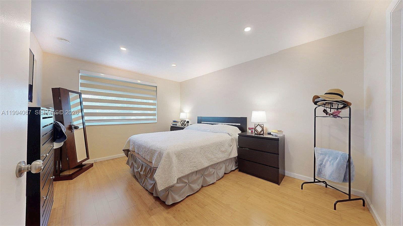 6840 Southwest 45th Lane, Unit 5 Miami, FL 33155 - Photo 27 of 34 a bedroom with a bed and a flat tv screen on a dresser