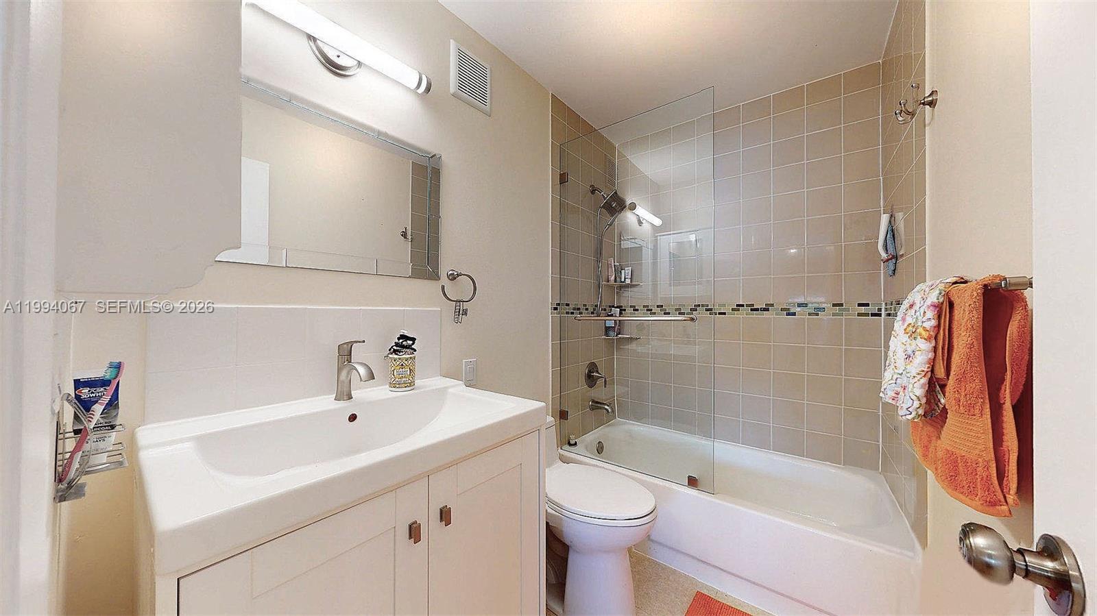6840 Southwest 45th Lane, Unit 5 Miami, FL 33155 - Photo 28 of 34 a bathroom with a sink toilet a mirror and shower