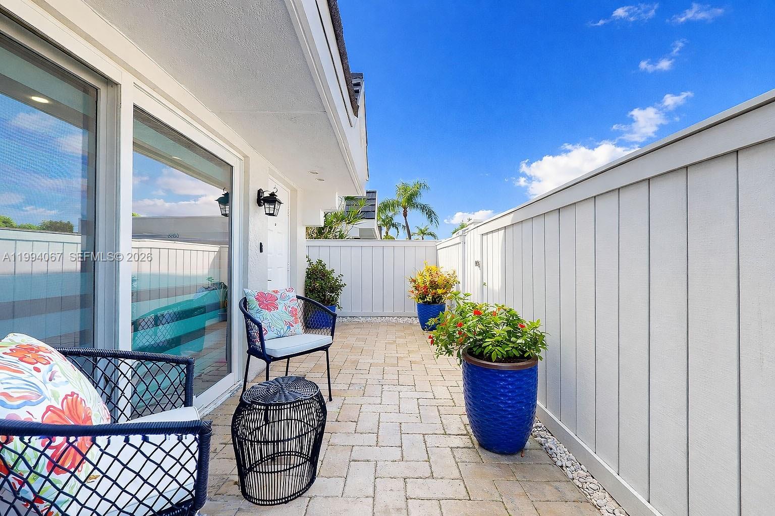 6840 Southwest 45th Lane, Unit 5 Miami, FL 33155 - Photo 5 of 34 a view of a porch with furniture and potted plants