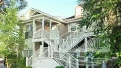 a front view of a house with a small yard and potted plants