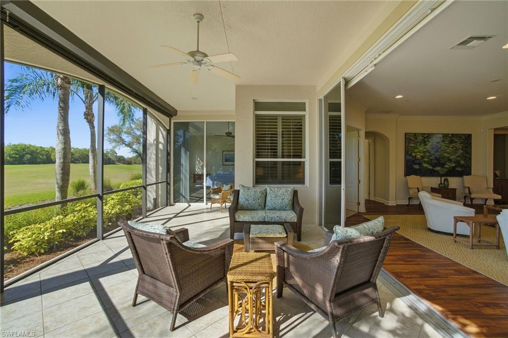 17015 Porta Vecchio Way, Unit 101 Naples, FL 34110 - Photo 23 of 39 a living room with furniture and floor to ceiling windows