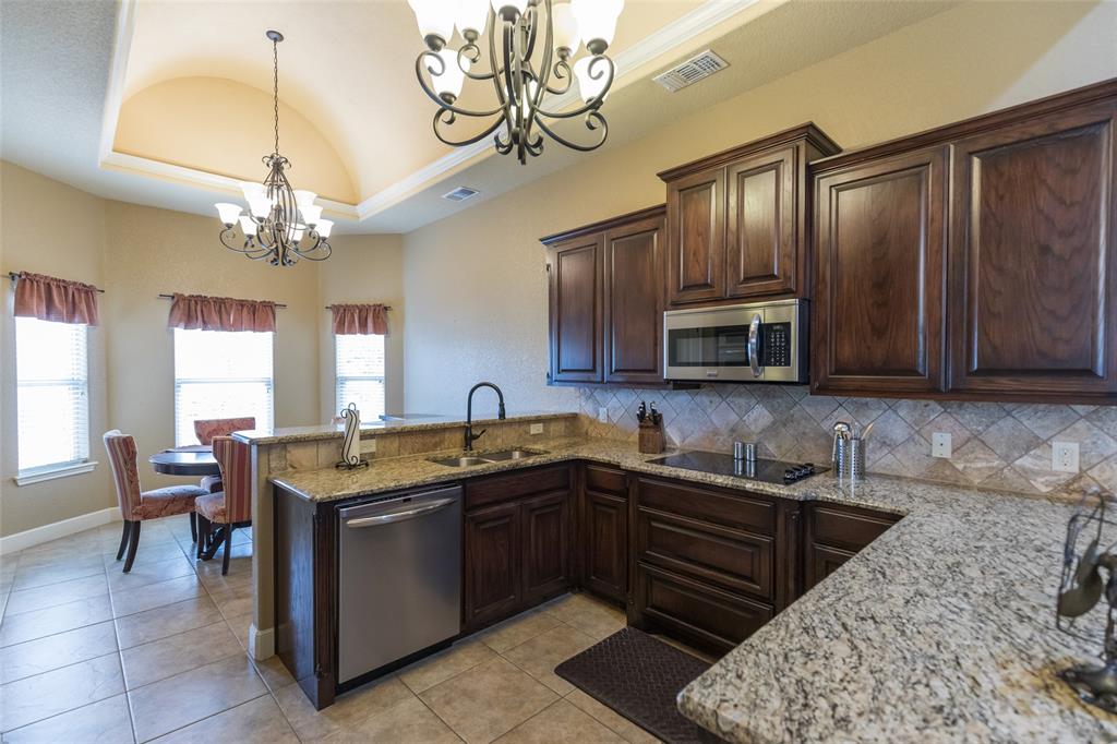297 Magnum Street Tuscola, TX 79562 - Photo 15 of 35 a kitchen with stainless steel appliances granite countertop a sink dishwasher stove and refrigerator with wooden floor