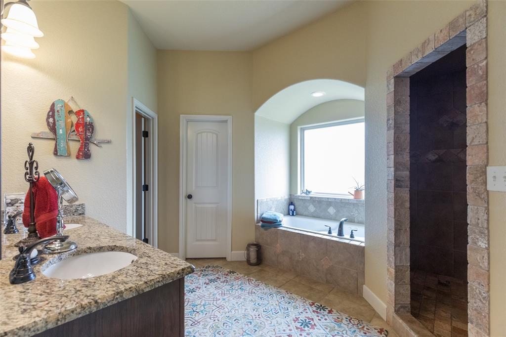297 Magnum Street Tuscola, TX 79562 - Photo 19 of 35 a bathroom with a granite countertop sink and a mirror