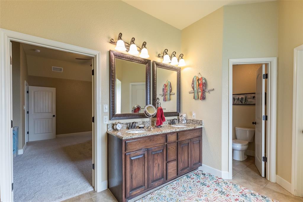 297 Magnum Street Tuscola, TX 79562 - Photo 20 of 35 a spacious bathroom with a toilet sink and mirror