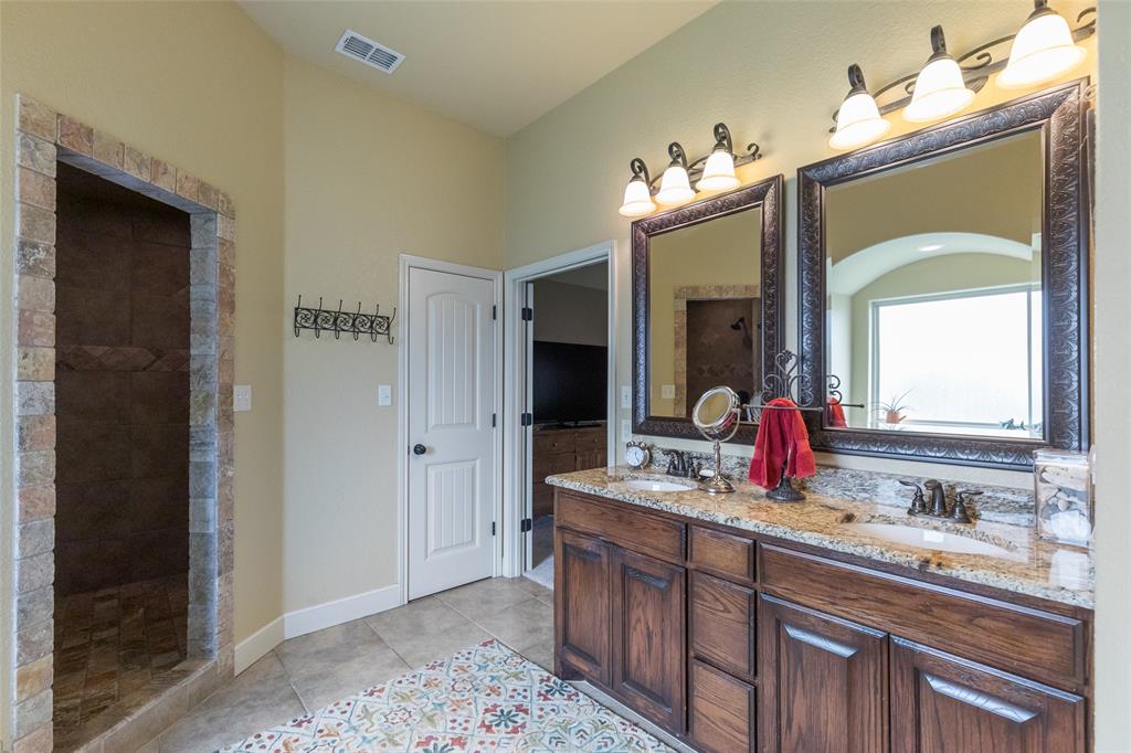 297 Magnum Street Tuscola, TX 79562 - Photo 21 of 35 a bathroom with a double vanity sink and a mirror