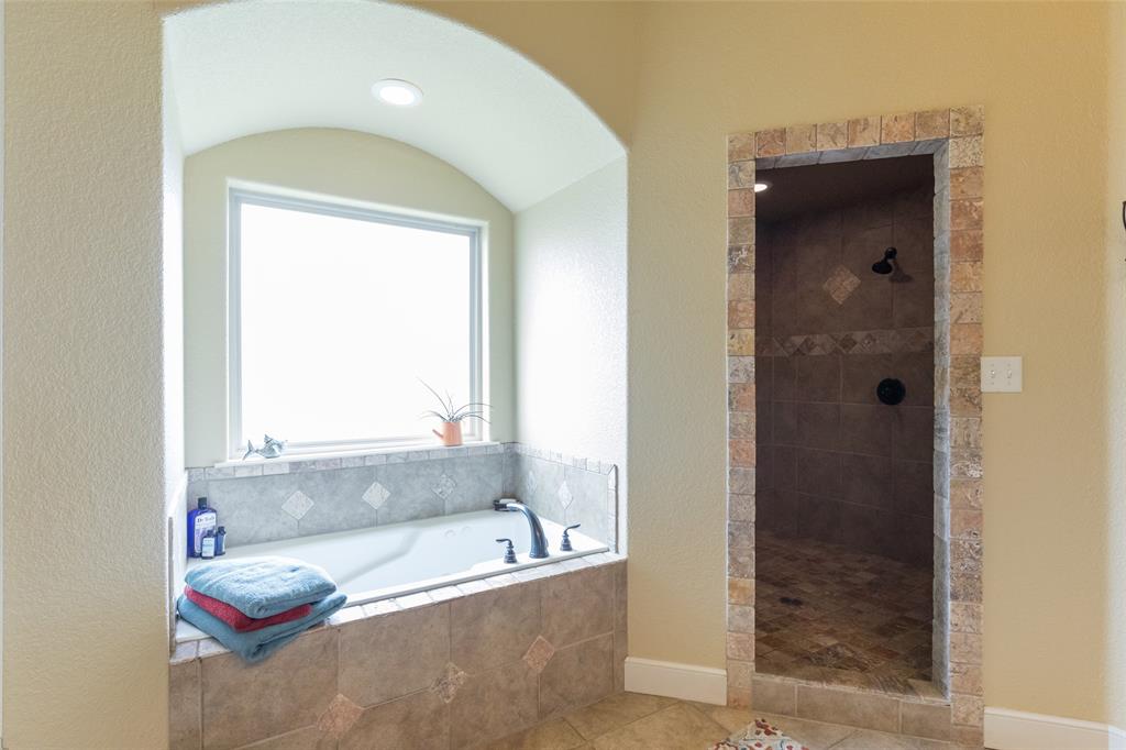 297 Magnum Street Tuscola, TX 79562 - Photo 22 of 35 a bathroom with a tub shower and a sink