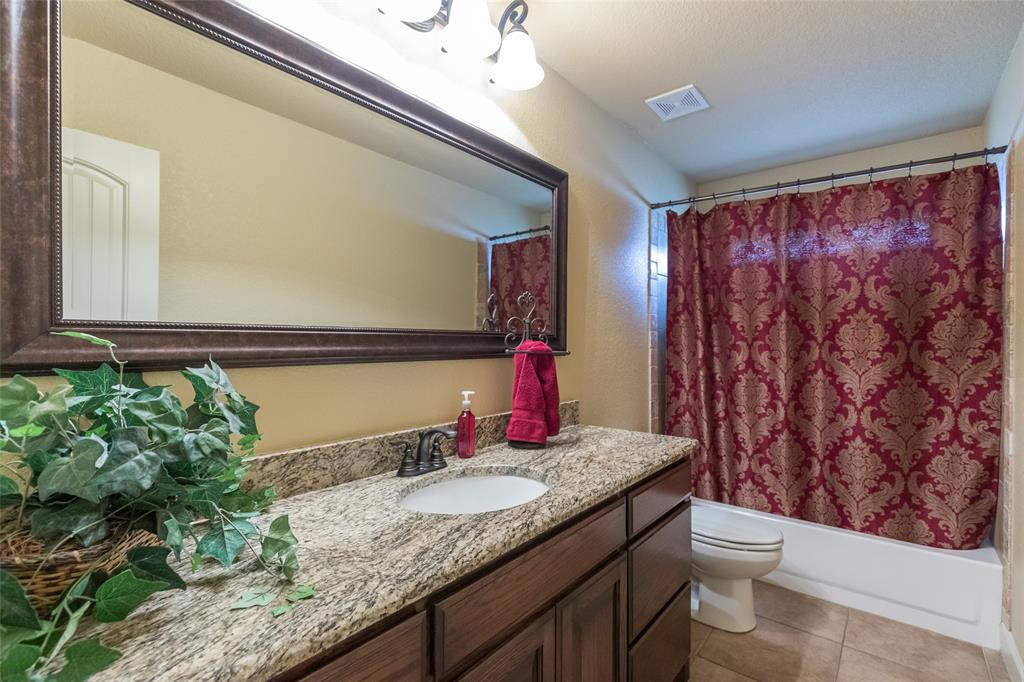 297 Magnum Street Tuscola, TX 79562 - Photo 26 of 35 a bathroom with a granite countertop sink and a mirror