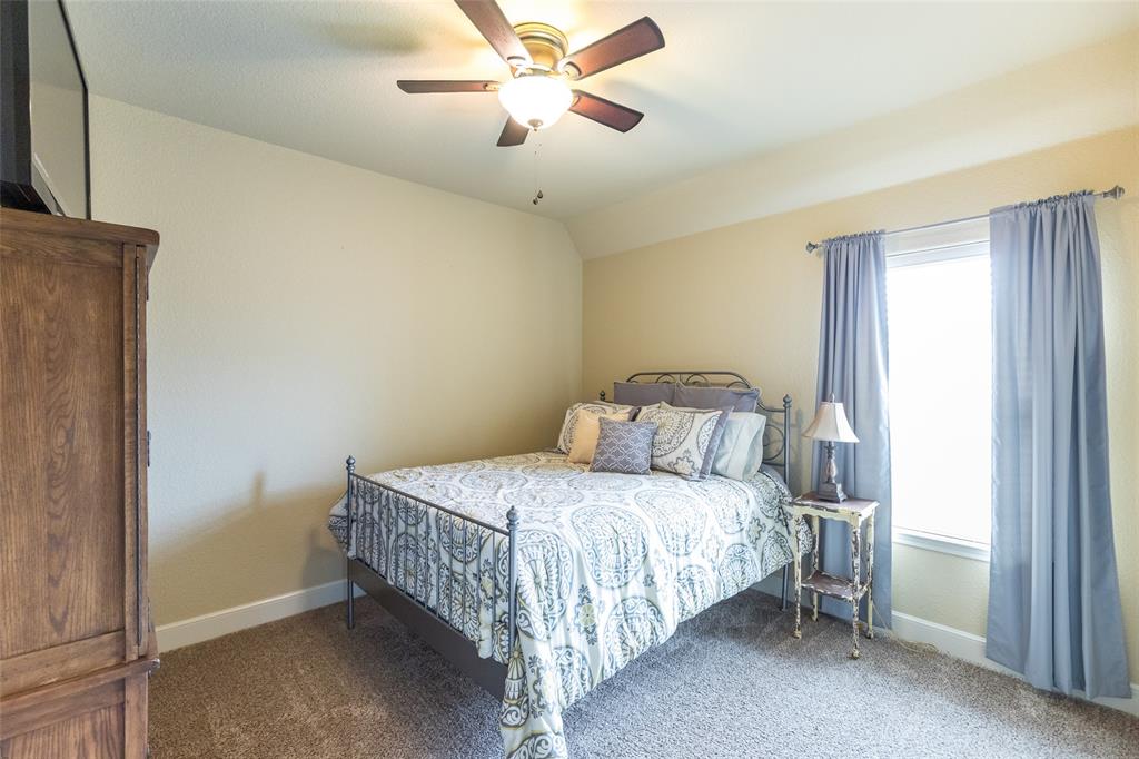 297 Magnum Street Tuscola, TX 79562 - Photo 27 of 35 a bedroom with a bed and a chandelier