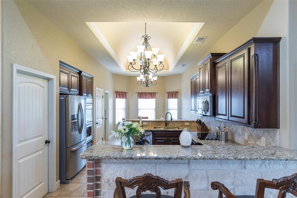 297 Magnum Street Tuscola, TX 79562 - Photo 10 of 35 a large kitchen with stainless steel appliances granite countertop a refrigerator a sink dishwasher a dining table and chairs