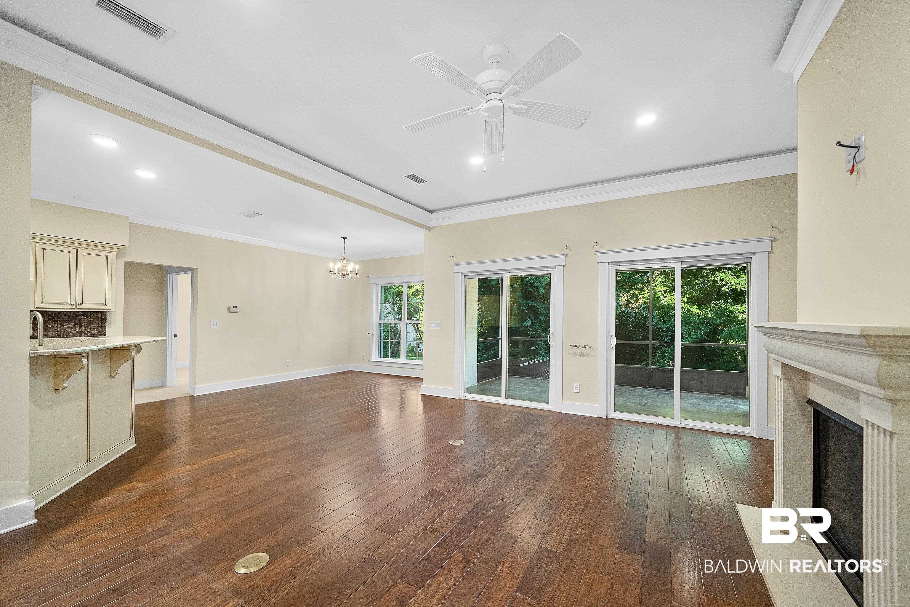 356 Liberty Street Fairhope, AL 36532 - Photo 5 of 39 Unfurnished living room with ornamental molding, dark wood-style floors, recessed lighting, a fireplace, and a chandelier