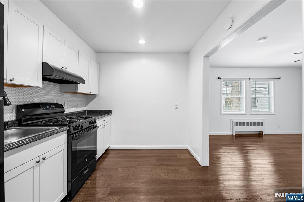 335 Paterson Avenue, Unit F East Rutherford, NJ 07073 - Photo 6 of 12 a kitchen with stainless steel appliances a stove and wooden floor