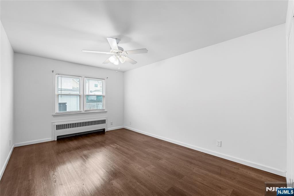 335 Paterson Avenue, Unit F East Rutherford, NJ 07073 - Photo 8 of 12 an empty room with wooden floor and windows