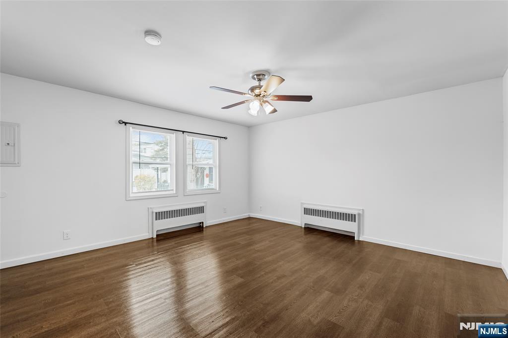 335 Paterson Avenue, Unit F East Rutherford, NJ 07073 - Photo 9 of 12 an empty room with windows and chandelier fan